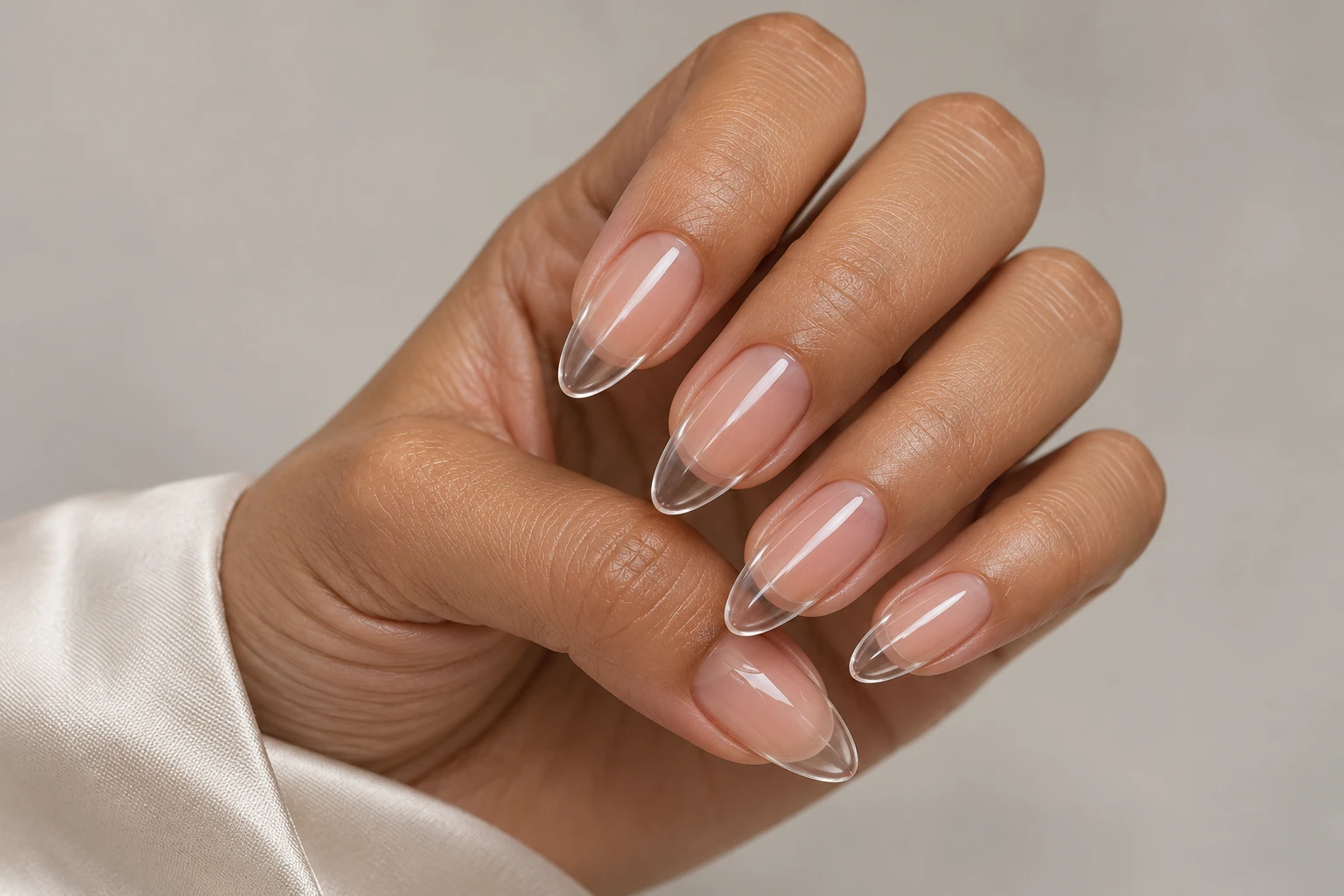 Almond-shaped nails with transparent extension tips and a glossy finish